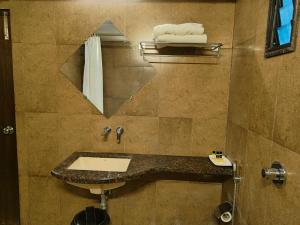 a bathroom with a sink and a mirror at Hotel Heritage 2001, Nagpur in Nagpur