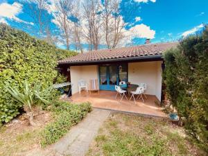 a house with a patio with a table and chairs at Gîtes de la villa du pin in Ruoms