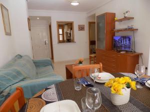 uma sala de estar com uma mesa e um sofá em Holiday Costa marina 3MED006 em El Borseral