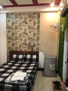 Un dormitorio con una cama en blanco y negro y una pared en Khách sạn thái bảo, en Thôn Mỹ Phước