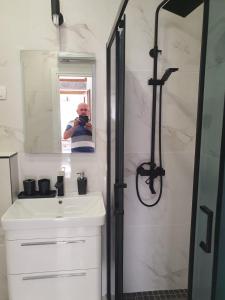 a person taking a picture of a bathroom with a sink and shower at Old Town Lux in Baška +26 photos