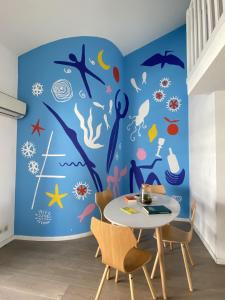 a dining room with a blue ocean themed wall at Appartement Duplex 4 personnes Quartier Riquier Nice in Nice