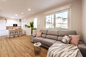 a living room with a couch and a kitchen at White Tree Rooms and Apartments in O Pedrouzo