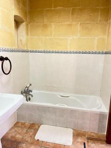 La salle de bains est pourvue d'une baignoire et d'un lavabo. dans l'établissement Sant Antnin B&B, à Munxar