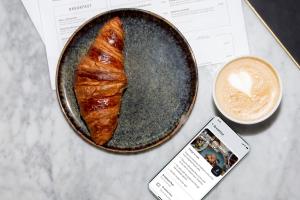 einen Tisch mit einem Teller Essen und einer Tasse Kaffee in der Unterkunft Bob W Sentralen in Oslo