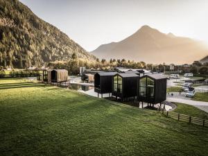 坎波图雷斯Såndgøld Alpine Glamping的村庄效果图，背景为一座山