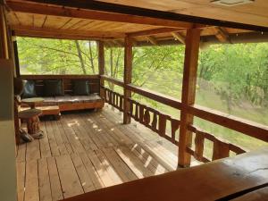 a porch with a bench on a wooden deck at Log cabin in Belgrade