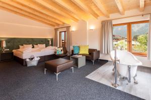 ein Hotelzimmer mit einem Bett und einer Badewanne in der Unterkunft Huber's Boutique Hotel in Mayrhofen