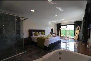 Villa Neo في Yamanlar: غرفة نوم مع سرير وحوض استحمام