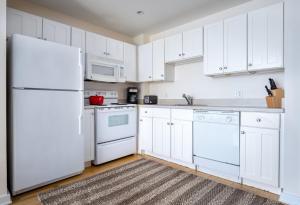 eine Küche mit weißen Schränken und einem weißen Kühlschrank in der Unterkunft Downtown 2BR w WD nr Boston Common BOS-244 in Boston