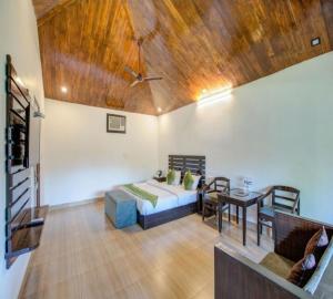 uma sala de estar com uma cama e uma mesa em Corbett Courtyard By The Tigers Pugmark em Belparāo