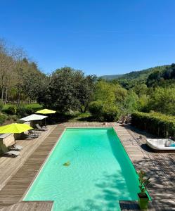 - une piscine avec des chaises et des parasols sur une terrasse dans l'établissement Gîte Nature en Luberon, à Céreste