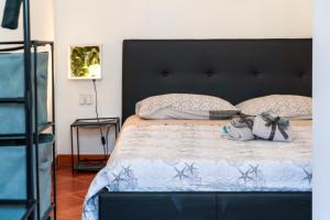a bedroom with a bed with a black headboard and pillows at VERY WELL apartment in Porto Torres