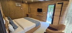 Schlafzimmer mit einem Bett, einem TV und einem Fenster in der Unterkunft Corbett Courtyard By The Tigers Pugmark in Belparāo