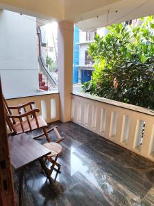 - un balcon avec 2 chaises, une table et 2 fenêtres dans l'établissement Brindaven, à Mysore