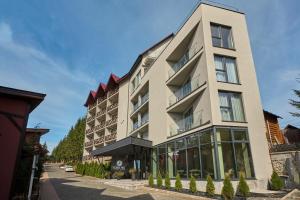 a large building with windows on a street at Forest Hill Hotel & SPA in Bukovel