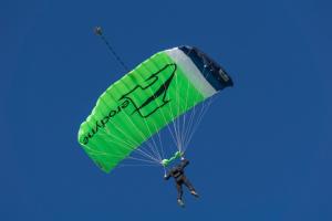 a man flying through the air with a green parachute at Holzhaus Onkel Fritz mit Sauna und Whirlwanne in Esch