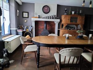 een eetkamer met een tafel en stoelen en een open haard bij La Source de Bury in Chambon-sur-Cisse