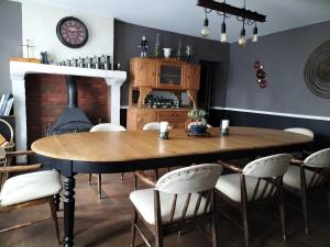 uma sala de jantar com uma mesa de madeira e cadeiras em La Source de Bury em Chambon-sur-Cisse