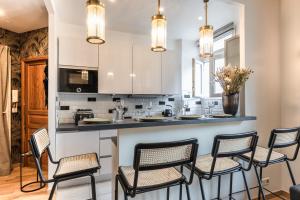 Una cocina con un mostrador con sillas alrededor. en Cosy & Design apartment 4 guests - Eiffel Tower, en París 15 fotos más