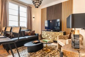 Una sala de estar con un sofá y un televisor. en Cosy & Design apartment 4 guests - Eiffel Tower, en París