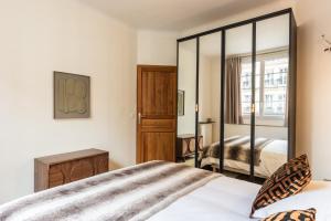 un dormitorio con una cama y un espejo en Cosy & Design apartment 4 guests - Eiffel Tower, en París