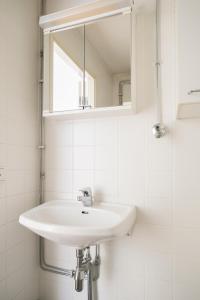 a white bathroom with a sink and a mirror at 2ndhomes Kluuvi Apartment 2 in Helsinki