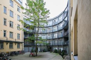 an external view of a building with a tree in the courtyard at 2ndhomes Kluuvi Apartment 2 in Helsinki