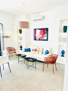 ein Wohnzimmer mit einem weißen Sofa und Stühlen in der Unterkunft Luxury Villa - La Balena Blu in Massa Lubrense