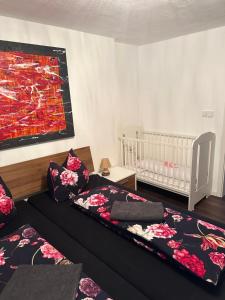 - une chambre avec 2 lits, un lit bébé et un tableau dans l'établissement Ferienwohnung Familie Dietze, à Hohenpeißenberg