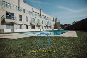a swimming pool in front of a large building at Suave Mar Flat by TonsdeVerde in Esposende