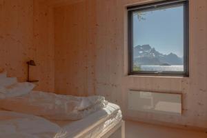 Schlafzimmer mit einem Bett und einem Fenster in der Unterkunft Minkfarmen, Spacious seaside cabin with scenic view in Ramberg