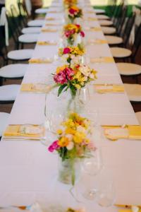 una mesa larga con jarrones llenos de flores. en Porsenna Resort en Villastrada