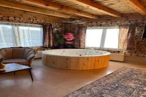 uma ampla casa de banho com uma banheira e uma cadeira. em Aşk-ı Nare Cave Hotel Swimming Pool Hot & SPA em Nevşehir