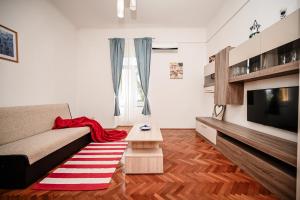 a living room with a couch and a television at Seafront Apartment Ičići in Ičići