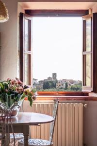 un tavolo e sedie di fronte a una finestra di Agriturismo - Collina Toscana Resort a Monsummano