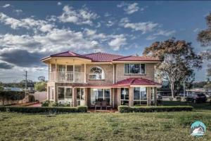 a house with a red roof at Aircabin - Tuggerawong - Lake Front - 9 Beds House in Karraganbah