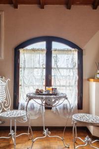 einen Tisch und zwei Stühle in einem Zimmer mit Fenster in der Unterkunft Agriturismo - Collina Toscana Resort in Monsummano