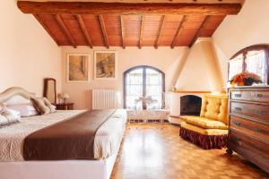 ein Schlafzimmer mit einem Bett, einer Kommode und einem Kamin in der Unterkunft Agriturismo - Collina Toscana Resort in Monsummano