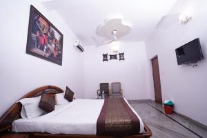 a bedroom with a bed and a flat screen tv at Hotel Lecston @Yashobhoomi Dwarka Sector - 25 metro station in New Delhi