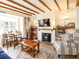 a living room with a fireplace and a table at Periwinkle Cottage in Loughborough