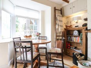 comedor con mesa, sillas y ventana en Periwinkle Cottage, en Loughborough