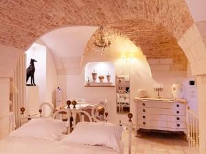a bedroom with two beds and a table in it at La Neviera dell'Arco in Martina Franca