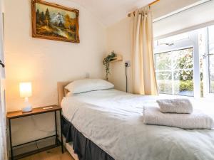 1 dormitorio con 2 camas y ventana en Periwinkle Cottage, en Loughborough