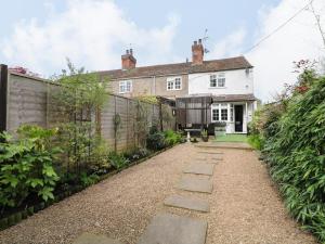 a house with a stone pathway in front of it at Periwinkle Cottage in Loughborough