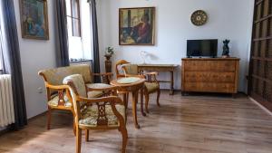 a living room with chairs and a table and a tv at BLKI Vendégház in Tihany
