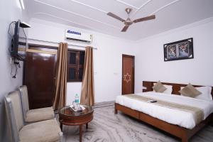 um quarto com uma cama, uma mesa e um sofá em Hotel Lecston @Yashobhoomi Dwarka Sector - 25 metro station em Nova Deli