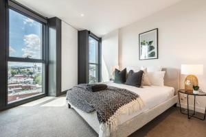 1 dormitorio con cama y ventana grande en Spacious 2 bedroom apartment with Free parking-00189 en Melbourne