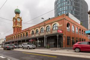 a large brick building with a clock tower on a street at Spacious 2 bedroom apartment with Free parking-00189 in Melbourne