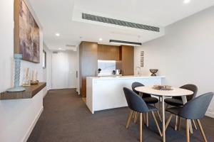 a kitchen and dining room with a table and chairs at Parque on St Kilda - 02532 in Melbourne